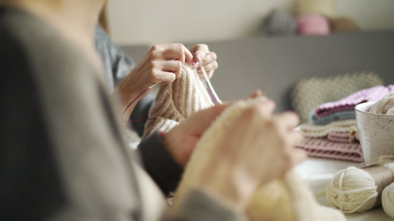 뜨개질을 하는 여자 손으로 모직물을 만든다. 여성 뜨개질 손