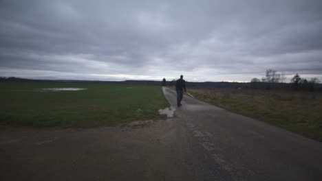 Modern-Black-Swordsman-Warrior-Awaiting-Battle-Opponent-in-Open-Field-Under-Grey-Sky,-Europe,-4K-|-Muscular,-Intimidating,-Shadow,-Figure,-Blurry,-Dark-Clothes,-Powerful,-Distant-Walk,-Angry-Slash