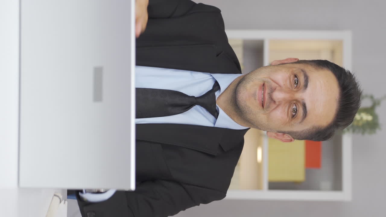 vídeo vertical de un trabajador de oficina en casa que dice que viene a la cámara, llamándote.