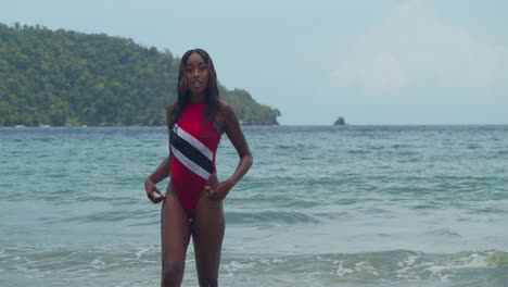 in the caribbean, on trinidad's north coast, a young girl in a trinidad flag bikini is on the beach