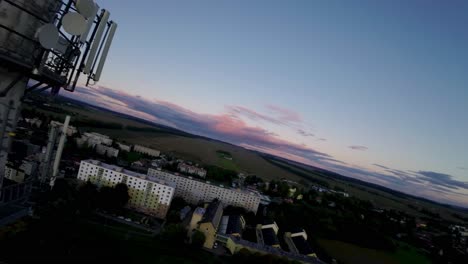chimenea alta con satélites fijos que transmiten una señal a los hogares de la ciudad