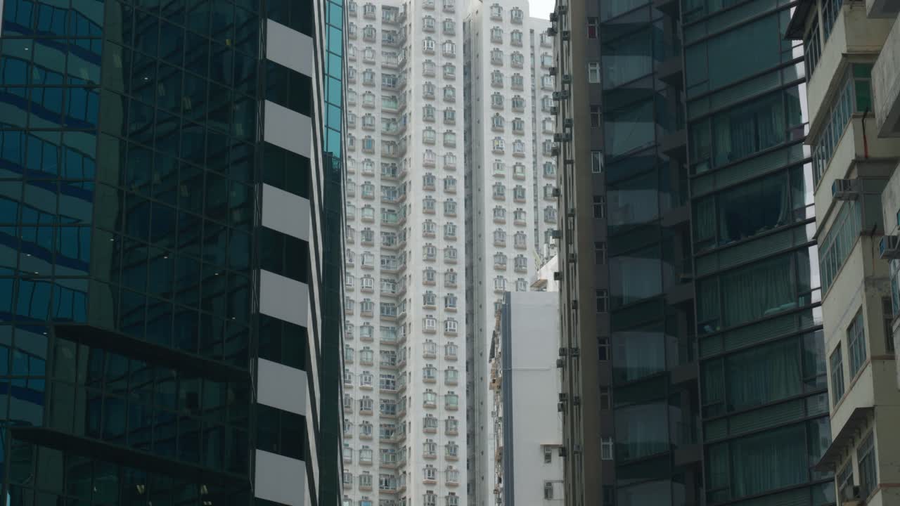 Vista panorámica de edificios de apartamentos y rascacielos en el centro de Hong Kong, China, en un día soleado, mostrando la densa vida urbana y la arquitectura moderna.