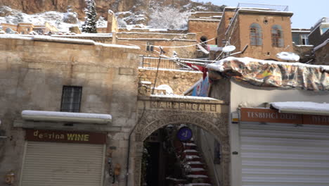 in het oude centrum van mardin zien we de winkels in de artuklu-bazaar ervoor en daarachter zien we historische stenen herenhuizen