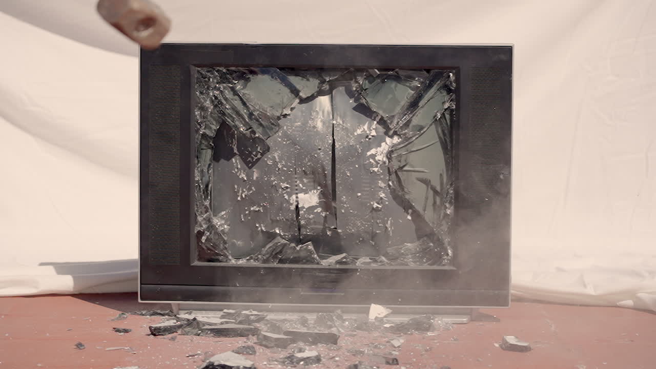 Rallentatore di un martello che spacca un vecchio schermo televisivo.