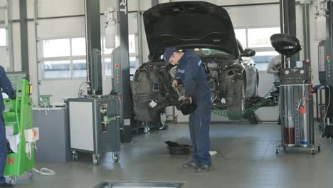 mechanic repairing car engine in auto workshop