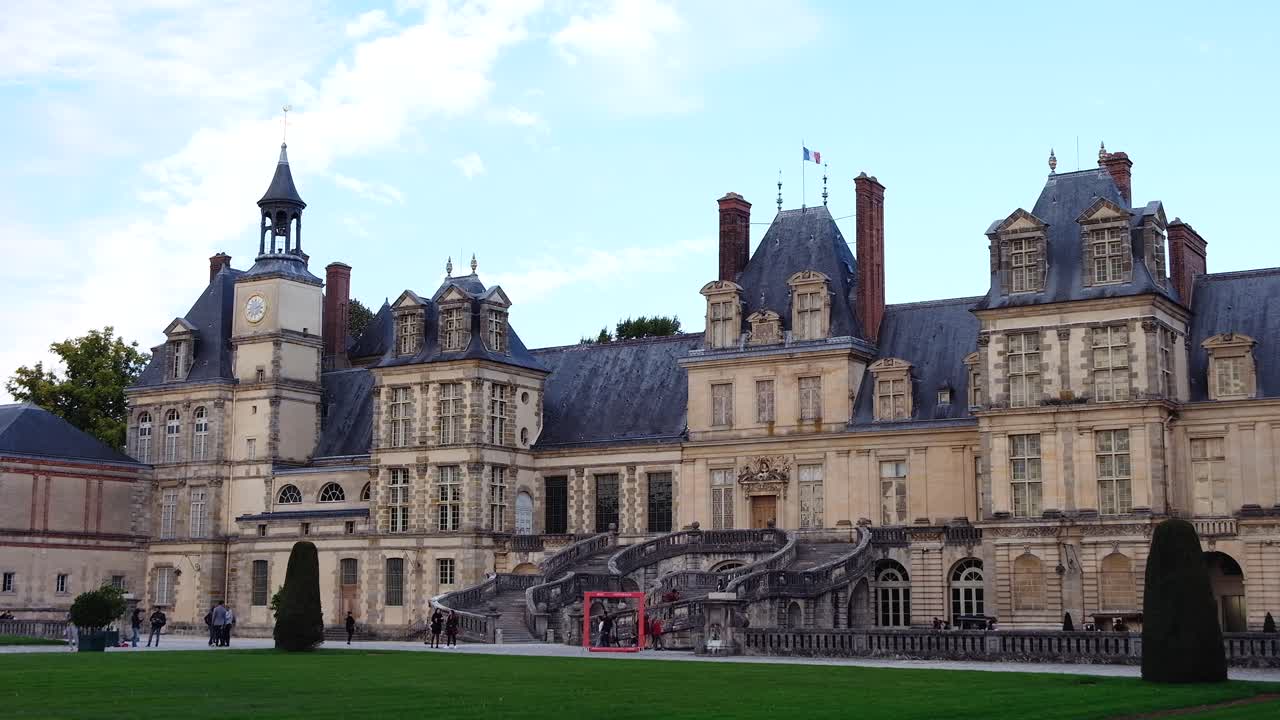 Fontainebleau, France - April 21, 2021: People walking in front of the Chateau de Fontainebleau castle in daylight