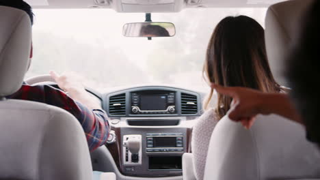 Dad-and-his-son-pointing-while-driving-in-car-with-mum