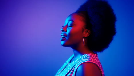 woman with afro bathed in vibrant neon lights