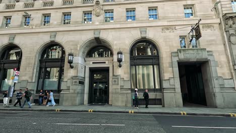 people walking by a historic building