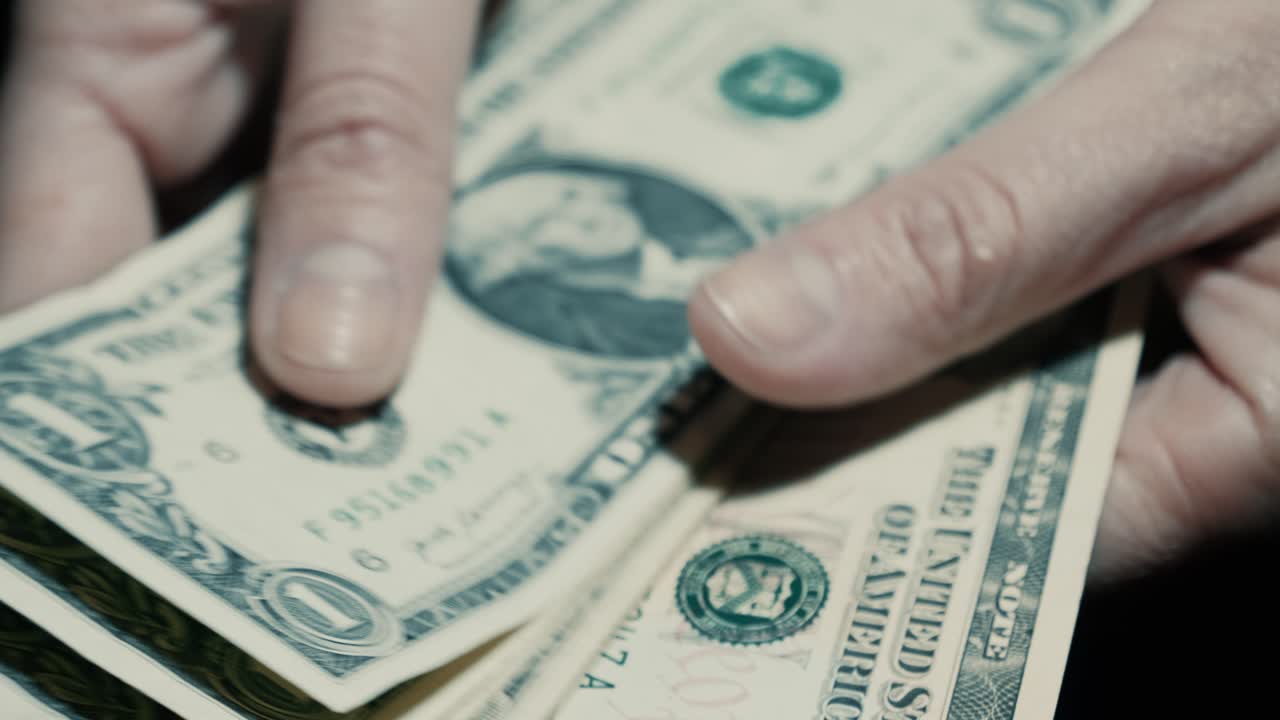 Nærbillede af hænder, der tæller én-dollar-sedler