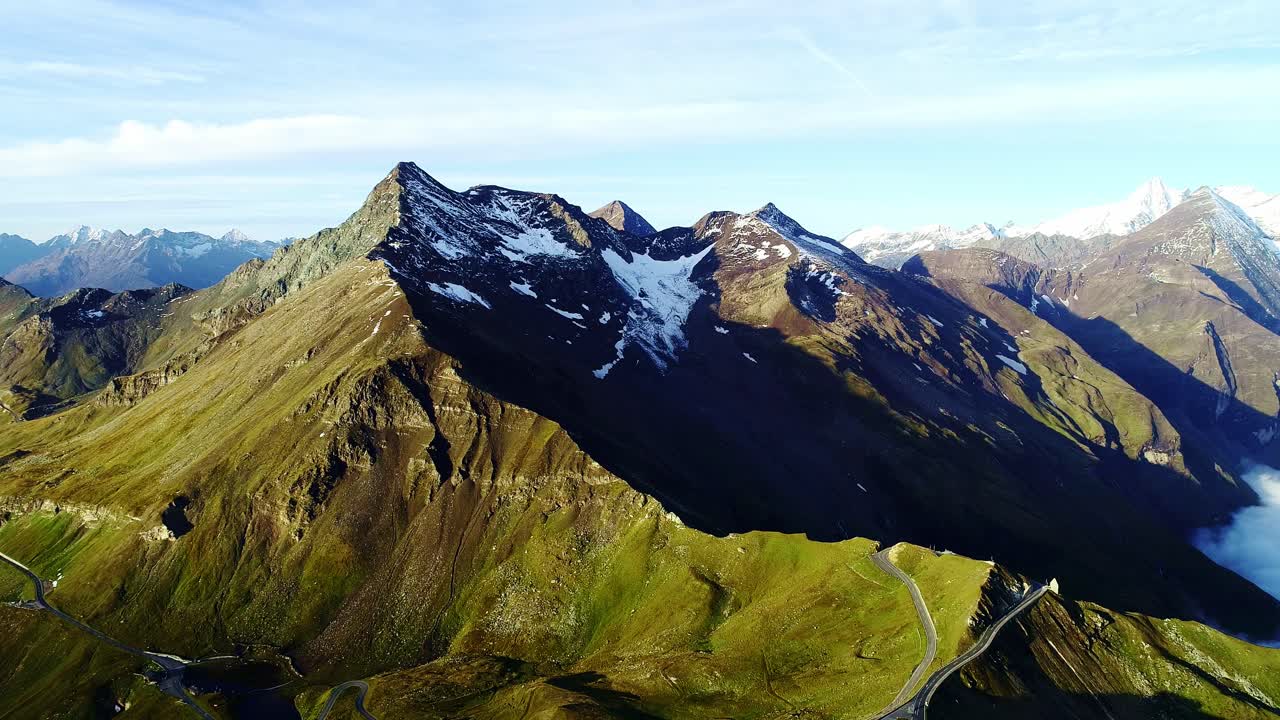 Breathtaking view of snow-capped mountains with clouds swirling below, Austria