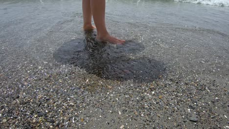 une photo des jambes d'une jeune femme jouant au ping-pong sur une plage de la mer