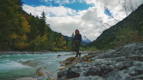 4K-UHD-Cinemagraph---seamless-video-loop-of-a-young-brunette-woman-standing-at-a-river-near-the-scenic-mountain-lake-Hintersee-in-Bavaria,-Germany
