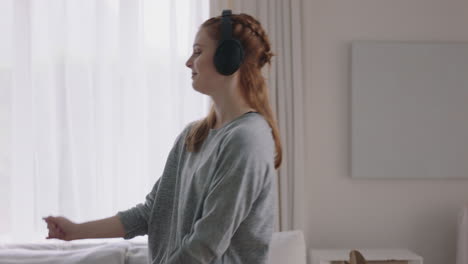 mujer feliz bailando en casa divirtiéndose escuchando música usando auriculares disfrutando de la celebración del fin de semana con movimientos de baile divertidos