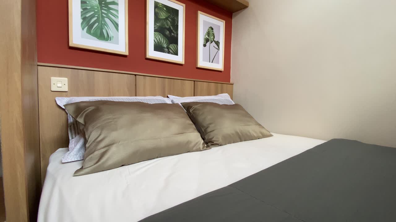 Showing a bedroom with soft and comfortable pillows and mattresses with a simple, aesthetic and elegant decoration theme.