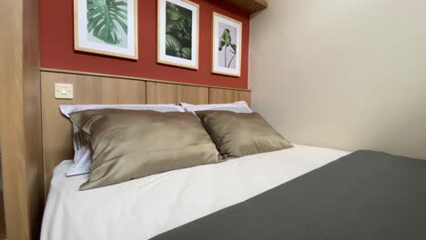 showing a bedroom with soft and comfortable pillows and mattresses with a simple, aesthetic and elegant decoration theme.