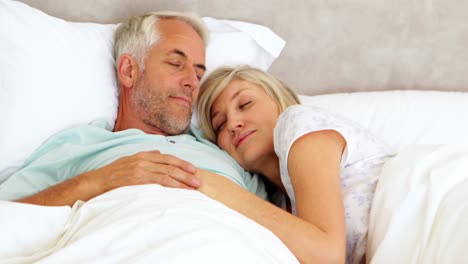 Couple-lying-in-bed-and-cuddling
