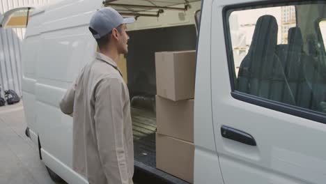 Joven-Conductor-De-Furgoneta-Con-Entrega-En-Almacén