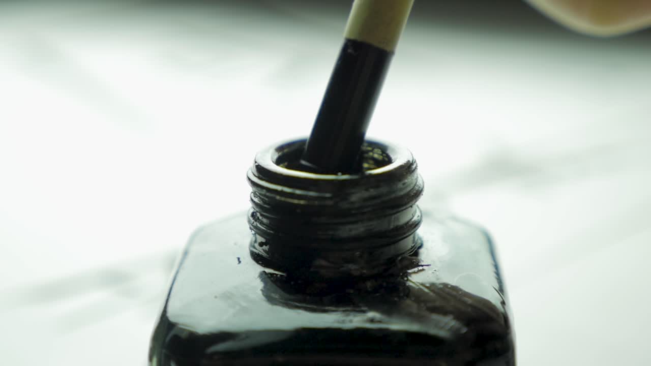 Remplir une bouteille d'encre noire avec un pinceau