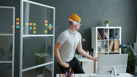 man dancing in office while listening to music