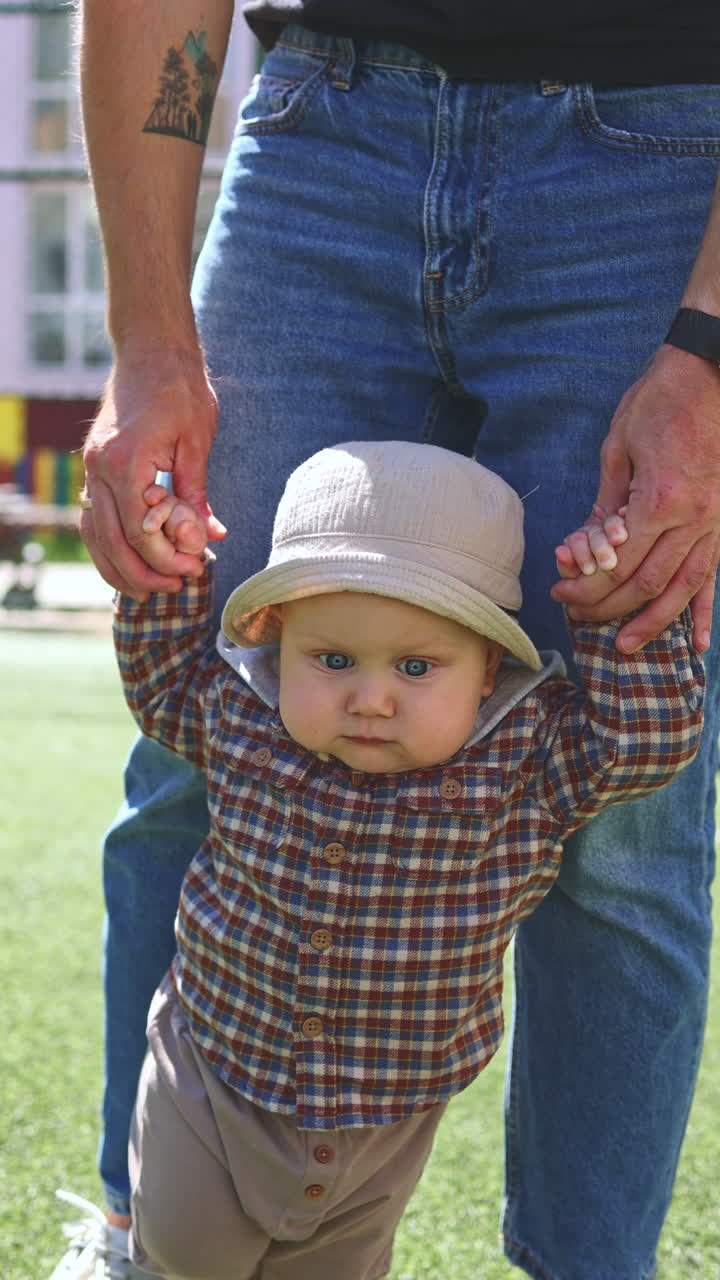 Una madre insegna al suo bambino a camminare. Il bambino impara a fare i primi passi. Sviluppo del bambino.