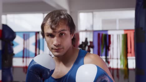 vista frontal de un hombre caucásico trabajando en un gimnasio de boxeo