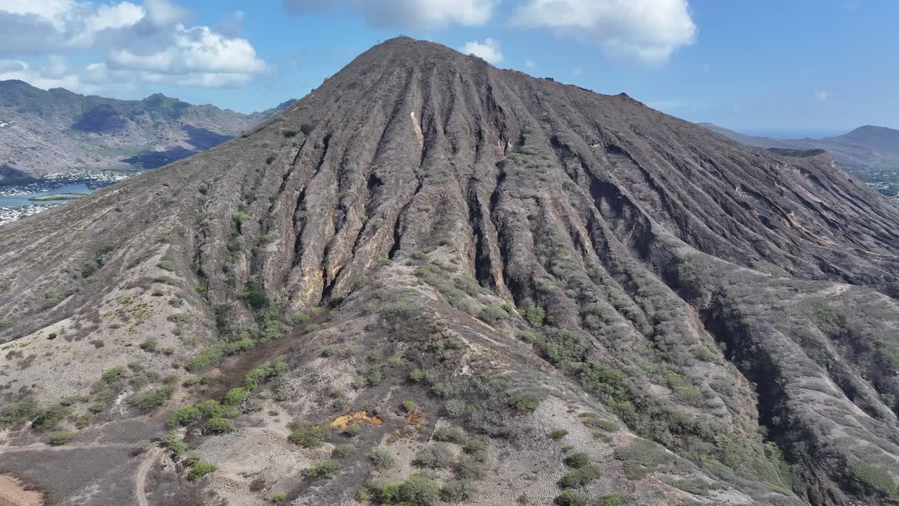 Aerial drone footage flying over Koko Head volcanic crater on Oahu, Hawaii, showcasing rugged cliffs, tropical landscapes, panoramic ocean views, and the island’s dramatic volcanic terrain
