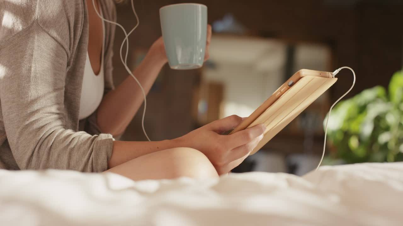 디지털 태블릿 기술을 사용하여 집에서 아름다운 금발 여성