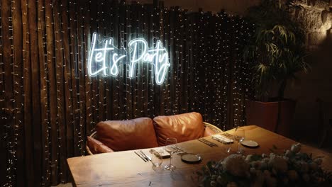 warm party setting with neon sign, wooden decor, and cozy seating arrangement