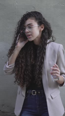 woman talking on phone in business casual outfit