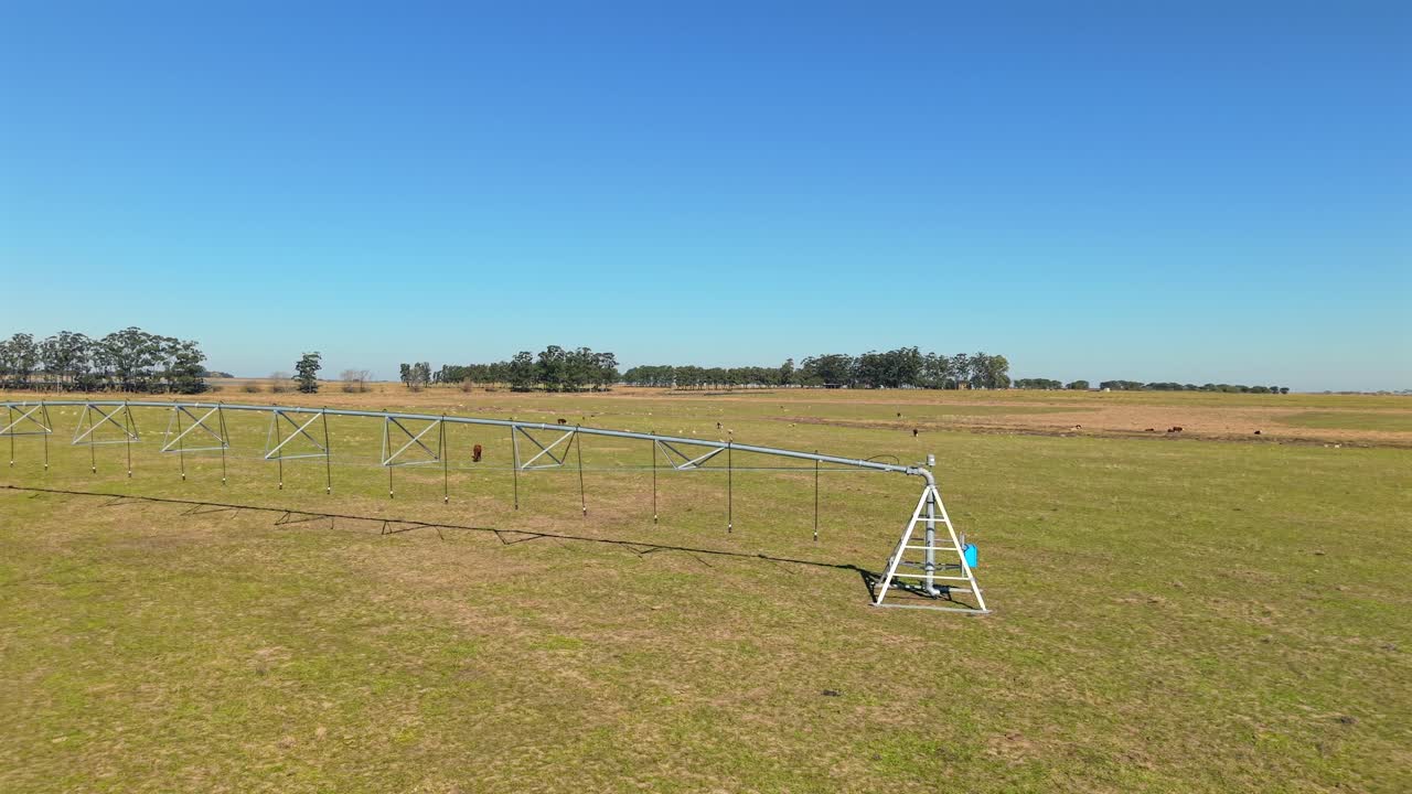 Part side of irrigation wheelbase structure placed on expanded green field on a rural landscape