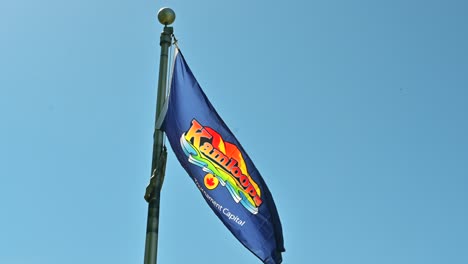 Volando-Con-Orgullo:-El-Logotipo-De-Kamloops-En-Una-Bandera,-Con-El-Telón-De-Fondo-De-Un-Cielo-Azul