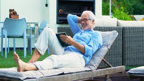 senior man reading a book in garden 4k