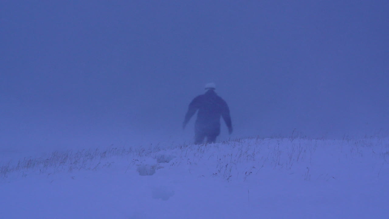 Woman disappearing in dramatic, heavy snowstorm