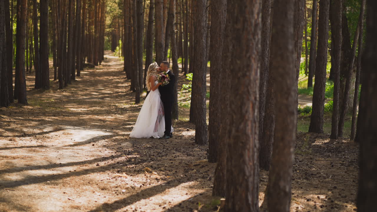 Sposa in abito nuziale con spacco bacia il marito.
