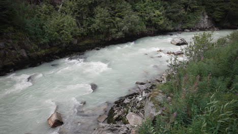 frozen river flowing from forest mountain streams in british columbia, canada