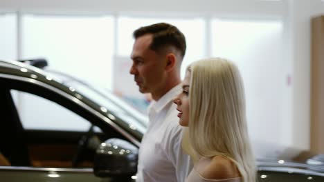 man with sexy blonde woman came to choose car in dealership