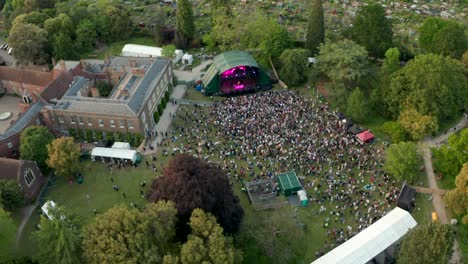 circling aerial shot over concert panning up to the london skyline