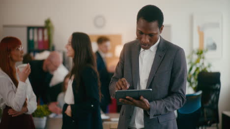 Confident-businessman-using-tablet-PC-in-office.