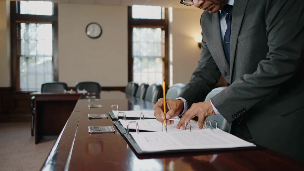 Scanning binder, man, dark suit, writing with yellow pencil for review at meeting room, copy space
