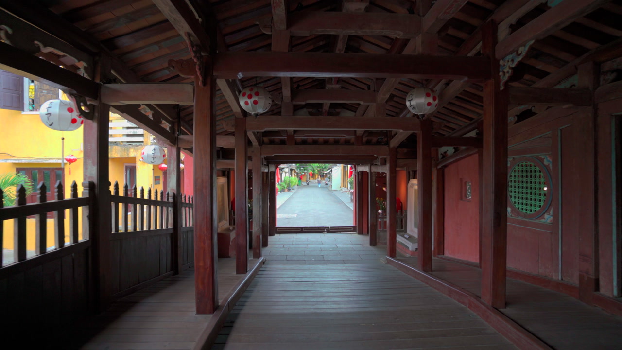 Dolly through historic Japanese covered bridge in Hoi An, Vietnam, cultural heritage spot, nobody