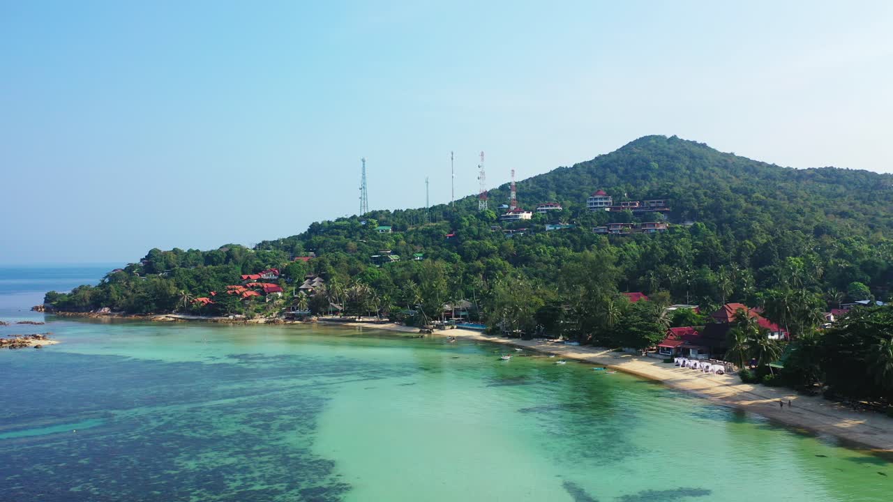 Koh Pha Ngan's west coast sandy Ao Nai Wok Beach and a hill covered with exotic trees