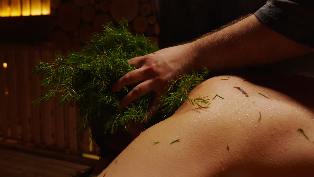 Man receiving juniper treatment in a sauna