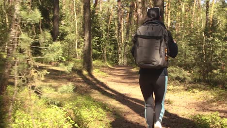 hiking woman walk with a hiking backpack in spring green forest