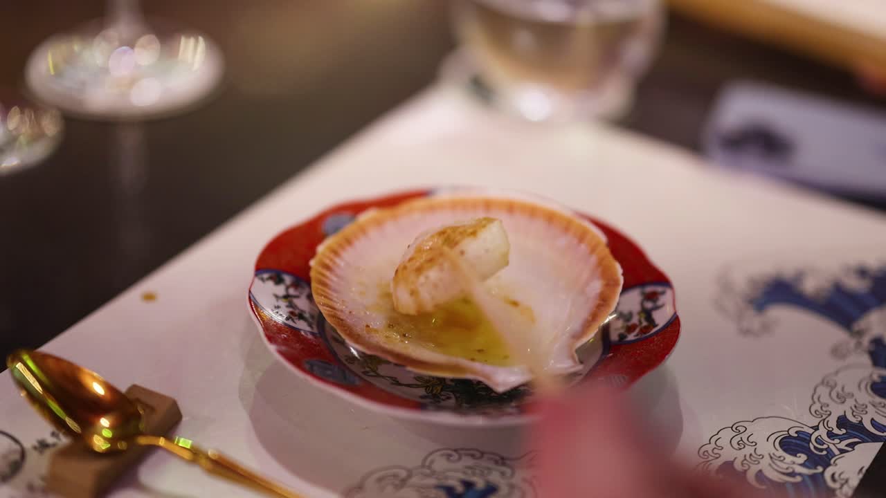 Close-up of a scallop being seared with a torch