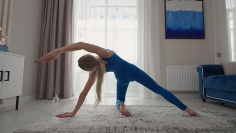 woman doing exercise at home. young woman practicing exercise at home. woman working out doing stretching exercise on yoga mat while