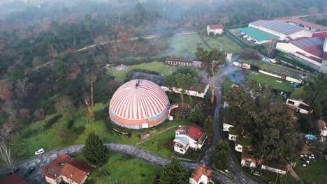 drone orbit around vibrant colorful orange blue circus tent of benposta ourense spain