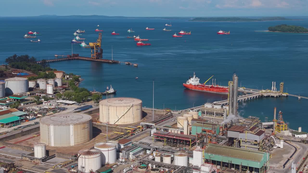 Expansive aerial view of the Rancha-Rancha Industrial Estate in Labuan, Malaysia, featuring the Petronas Methanol Plant and anchored oil tankers across the calm blue sea. Concept of energy production