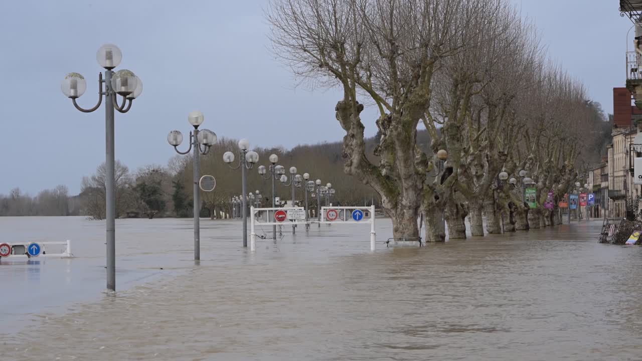 La Réole, Francia - 20 febbraio 2026: Veduta di edifici sommersi dalle acque alluvionali, con un'imponente torre che si erge sopra lo skyline