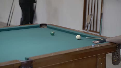 a player hammers a ball into a corner pocket during a pool game